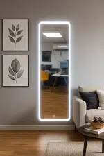 מראת קיר מודרנית עם תאורת LED היקפית, בעיצוב מלבני נקי ויוקרתי. המראה כוללת כפתור מגע תחתון להדלקה וכיבוי התאורה, לנוחות שימוש מקסימלית. מתאימה לסלון, חדר שינה או חדר כניסה, ומוסיפה אווירה יוקרתית וחמימה לכל חלל.